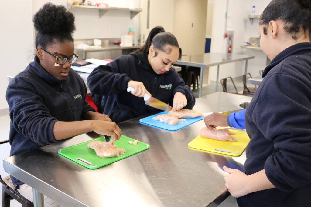 Nazareth Prep Students Cutting Chicken in Culinary Class